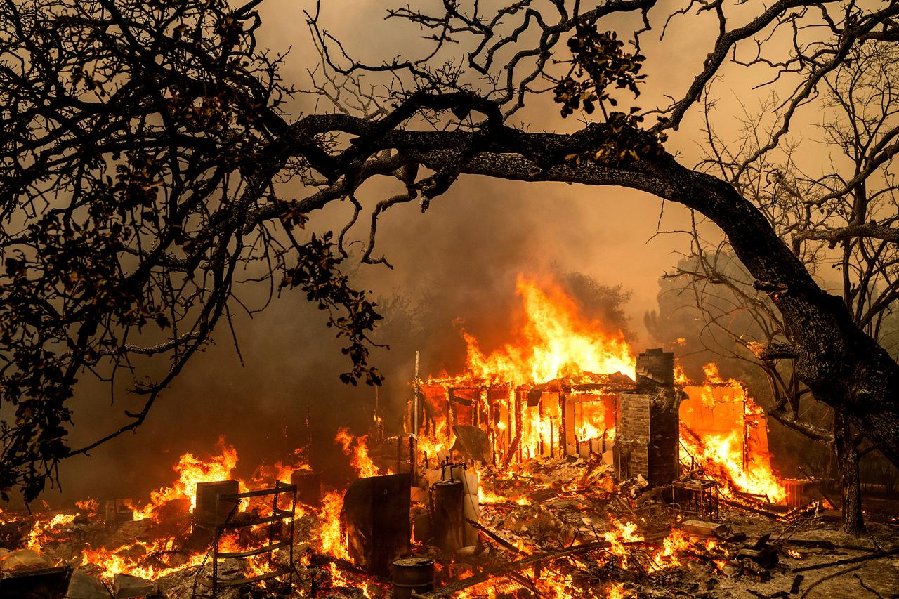 USA, Oroville: Flammen verzehren ein Gebäude in der Bessie Lane, während das Thompson Fire brennt