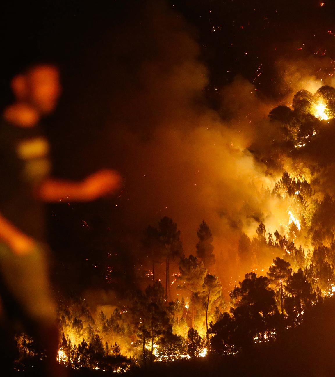 Ein Mann geht in der Nähe des Brandes von Quiroga. 