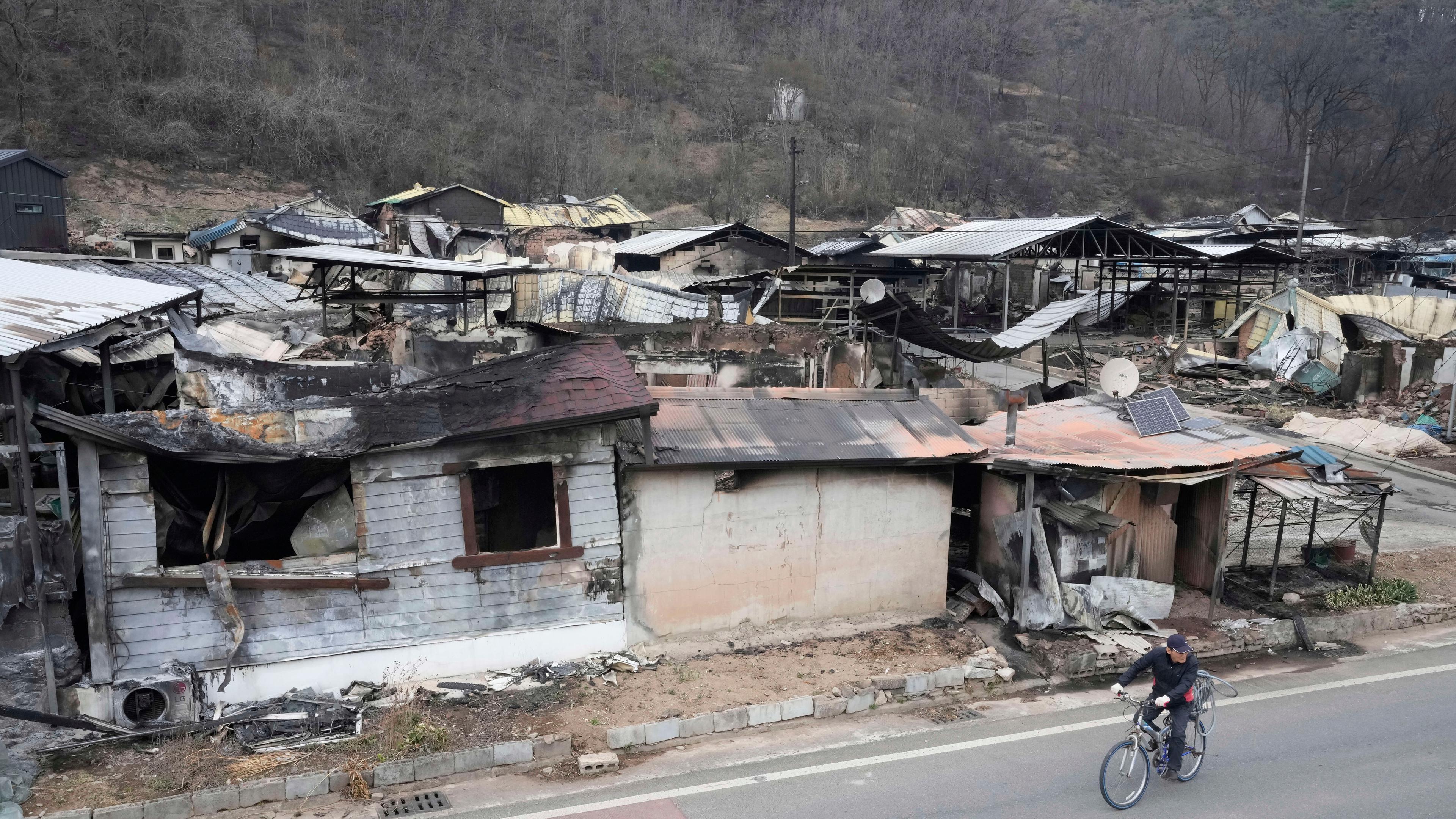 Südkorea, Andong: Ein Einwohner geht an ausgebrannten Häusern in einem durch Waldbrände beschädigten Dorf in Andog vorbei.