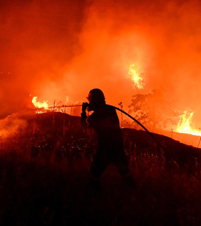 Ein Feuerwehrmann bekämpft einen Waldbrand am Stadtrand der im Norden Griechenlands gelegenen Stadt Thessaloniki.