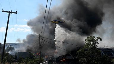 Ein Hubschrauber wirft Wasser über einen Waldbrand am Stadtrand der im Norden Griechenlands gelegenen Stadt Thessaloniki ab. 