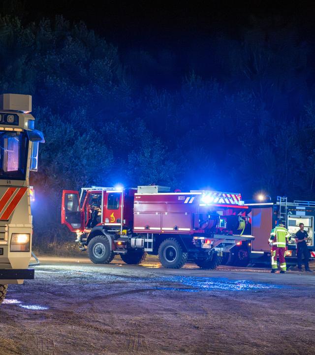 Rettungskräfte von Polizei und Feuerwehr sind bei einem Waldbrand im Einsatz