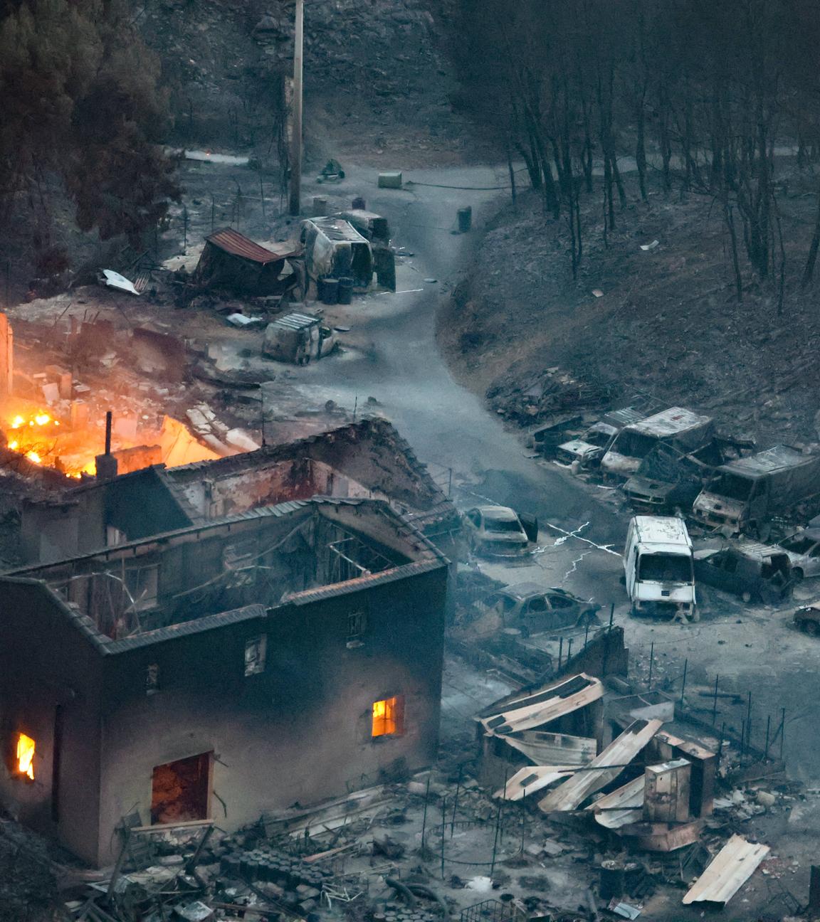 Frankreich, Marseille: Die Folgen eines Feuers hinterlassen ein abgebranntes Haus und abgebrannte Autos.