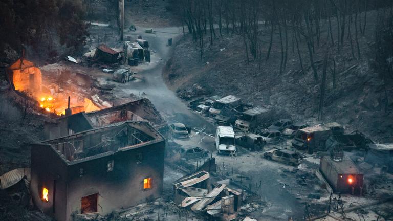 Frankreich, Marseille: Die Folgen eines Feuers hinterlassen ein abgebranntes Haus und abgebrannte Autos.
