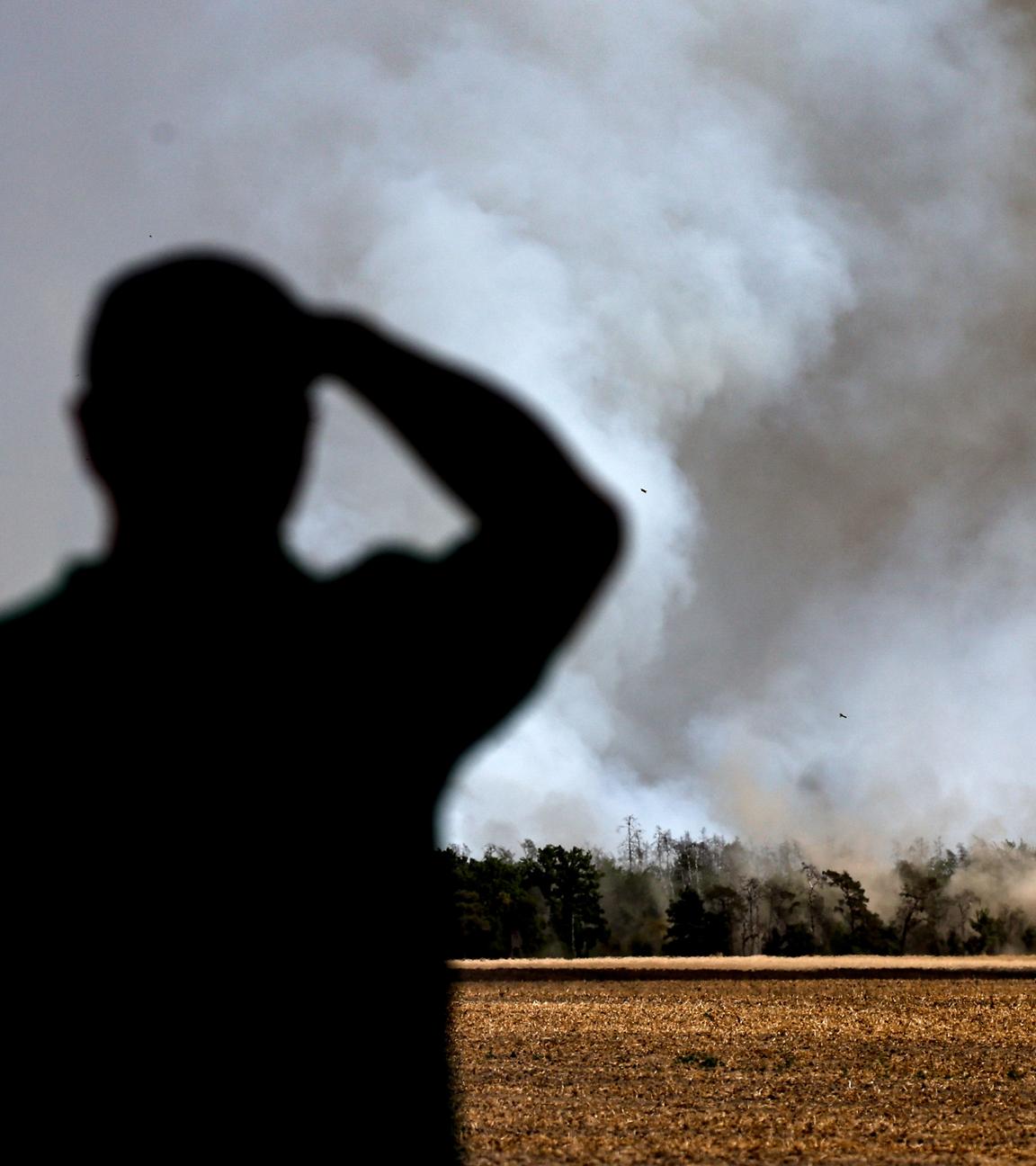 Ein Mann beobachtet die Rauchwolke, die von einem Waldbrand in der Gohrischheide bei Zeithain, Sachsen, Deutschland, aufsteigt, 04. Juli 2025.