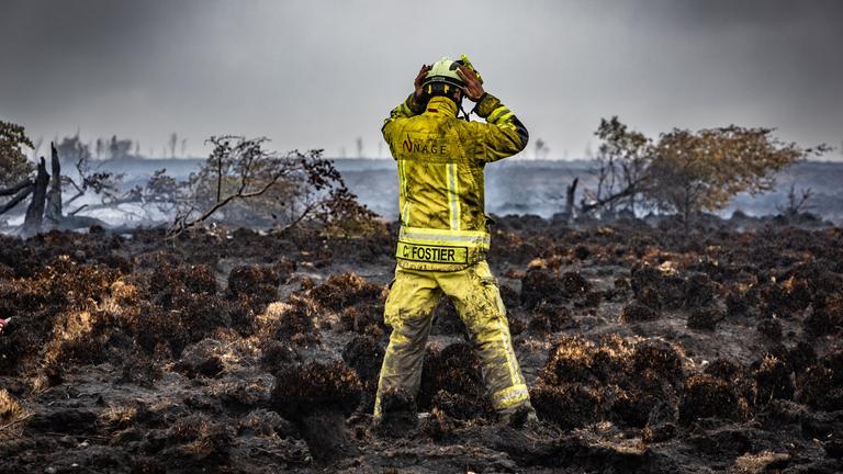 Ein Feuerwehrmann steht am Brandort im Naturschutzgebiet Hohes Venn, aufgenommen am 18.08.2026