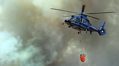 in Helikopter nimmt Wasser in Löschwasser-Außenlastbehältern zum Einsatz beim Waldbrand im Hürtgenwald auf.