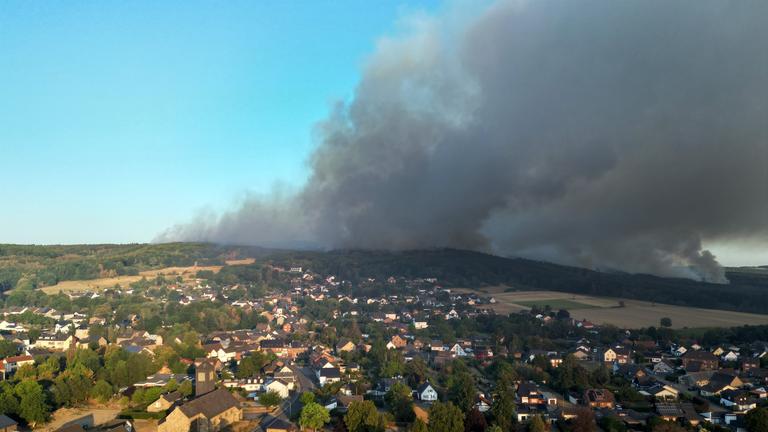 Dichter Rauch eines Waldbrands im Hürtgenwald zieht über den Ortsteil Gey (Aufnahme mit Drohne). 