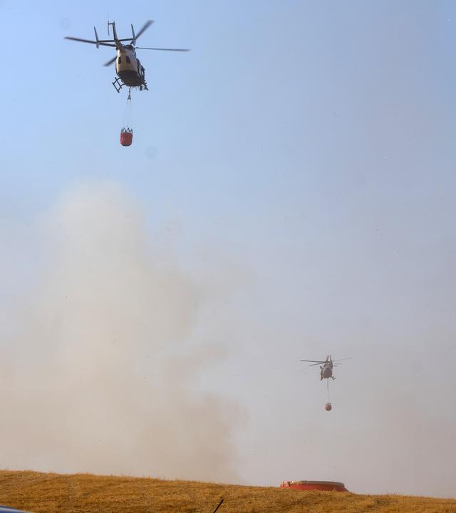 Zwei Polizeihubschrauber bekämpfen einen Waldbrand zwischen Langenfeld. 