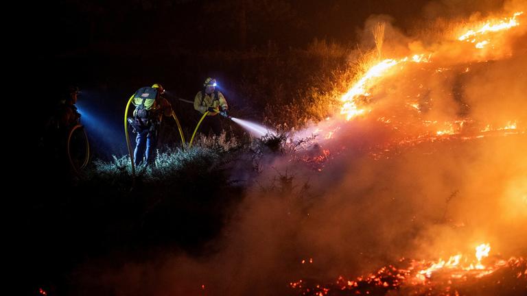 Feuerwehrleute von Cal Fire bekämpfen den Brückenbrand, der Berggemeinden nordöstlich von Los Angeles in Wrightwood, Kalifornien