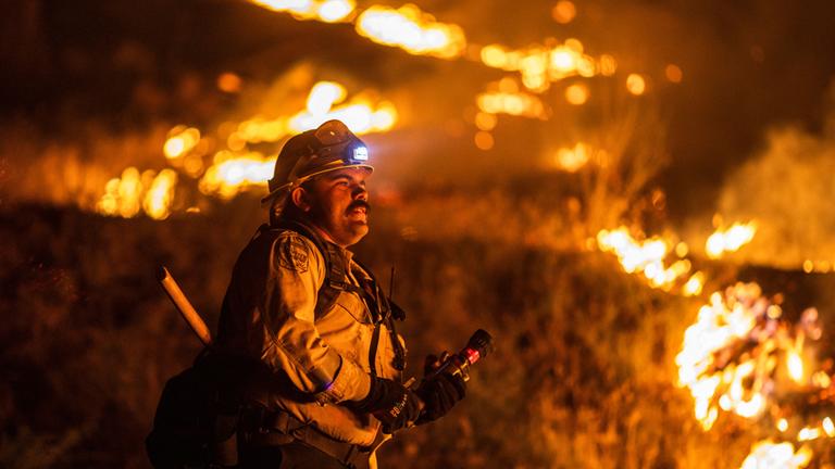 Ein Feuerwehrmann von Cal Fire bekämpft den Brückenbrand, der Berggemeinden nordöstlich von Los Angeles in Wrightwood, Kalifornien