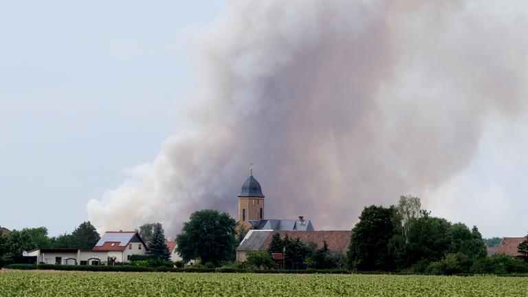 Sachsen, Wülknitz: Rauch eines Waldbrandes steigt über dem Dorf Lichtensee (Landkreis Meißen) auf.