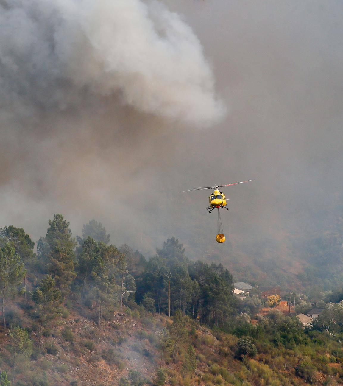 Ein Hubschrauber transportiert Wasser zum Löschen des Feuers in Quiroga, Spanien.