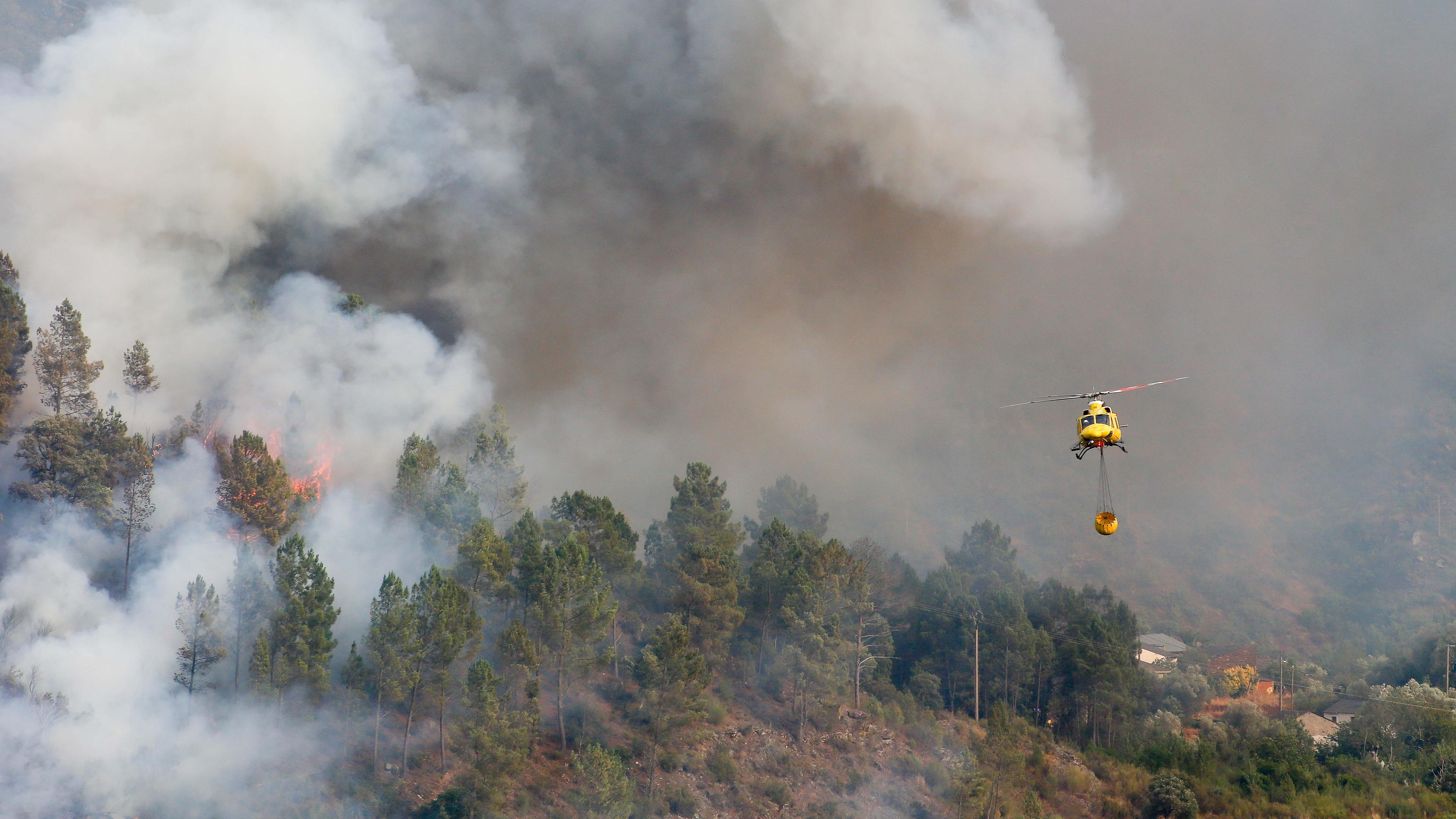 Ein Hubschrauber transportiert Wasser zum Löschen des Feuers in Quiroga, Spanien.