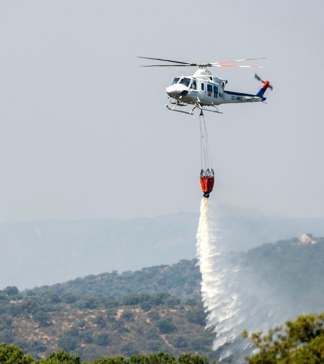 Ein Löschflugzeug wirft Wasser auf einen Waldbrand ab.