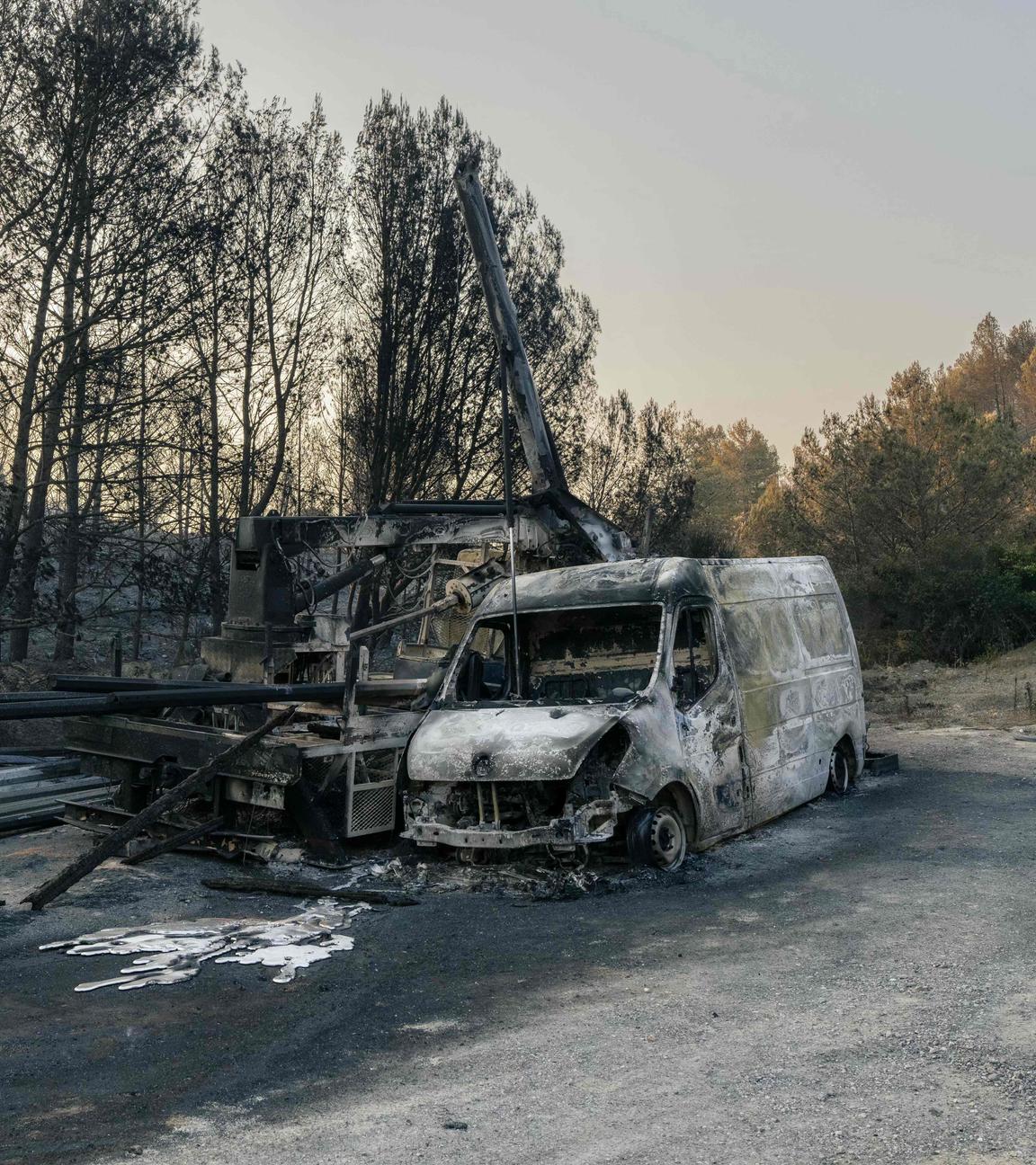 Dieses Foto zeigt ein ausgebranntes Fahrzeug in einem Waldgebiet, das am 7. August 2025 von einem Waldbrand in Coustouge in Südfrankreich heimgesucht wurde.