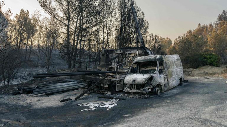 Dieses Foto zeigt ein ausgebranntes Fahrzeug in einem Waldgebiet, das am 7. August 2025 von einem Waldbrand in Coustouge in Südfrankreich heimgesucht wurde.