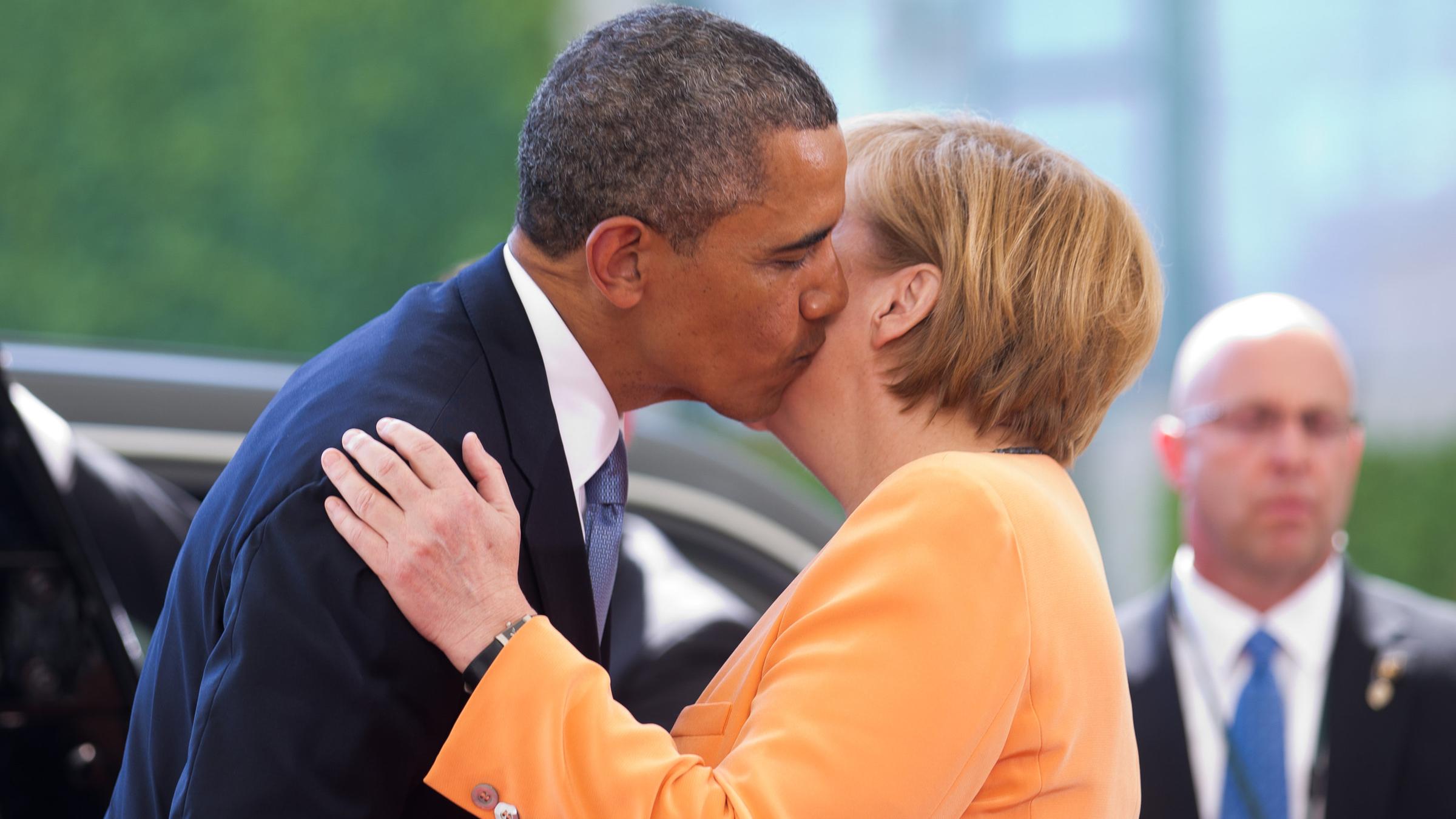 Barack Obama und Angela Merkel küssen sich auf die Wange.