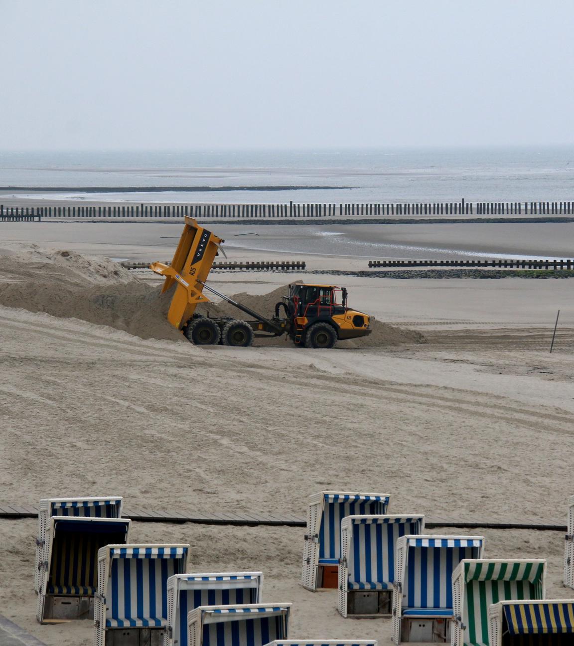 Wangerooge: Ein Muldenkipper, ein sogenannter Dumper, fährt am Badestrand Sand auf. 