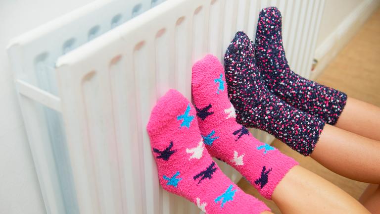 Kinder wärmen Füße an Heizkörper