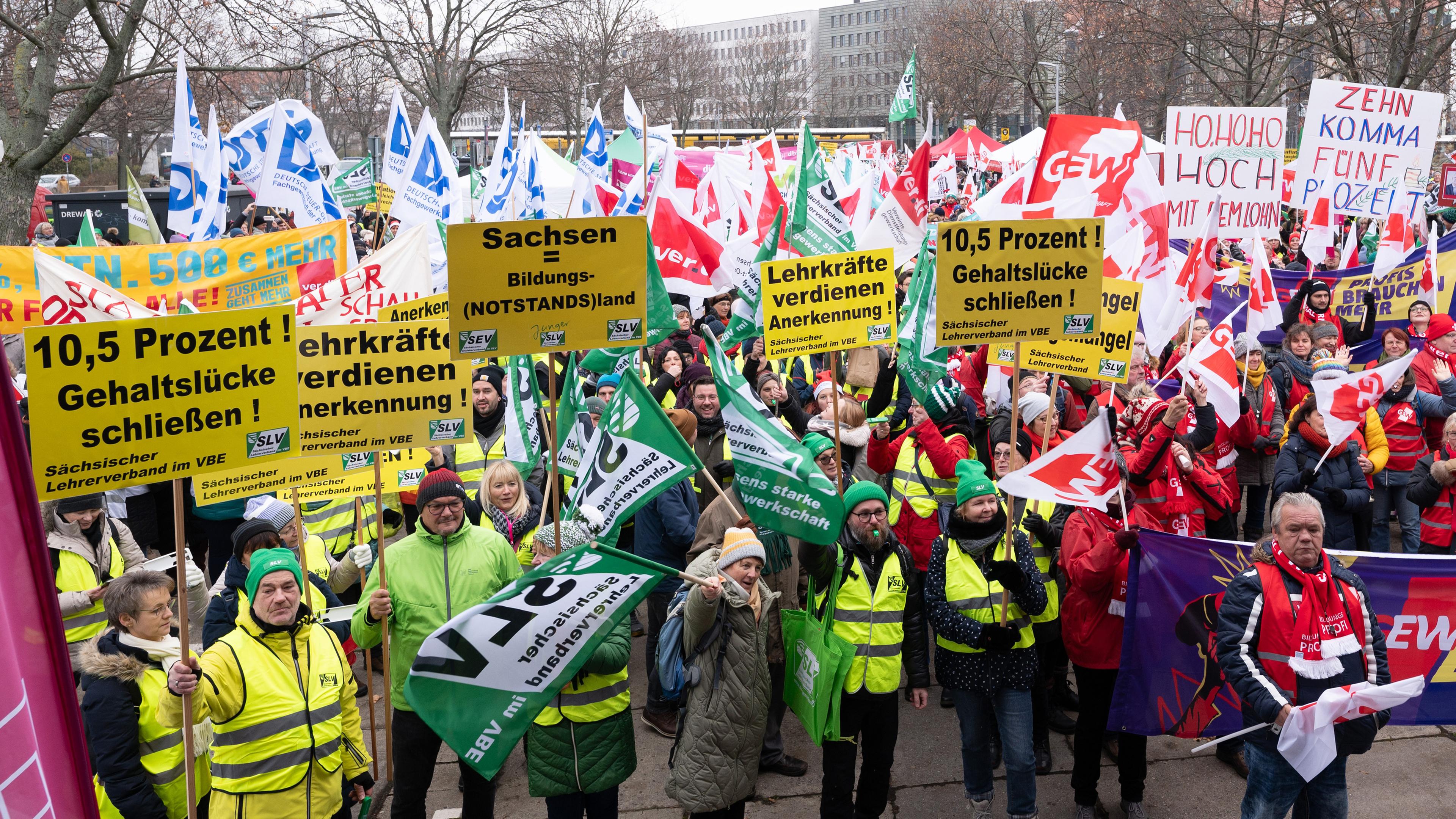 Teilnehmer einer Kundgebung der Bildungsgewerkschaft GEW stehen auf dem Carolaplatz am 06.12.2023.