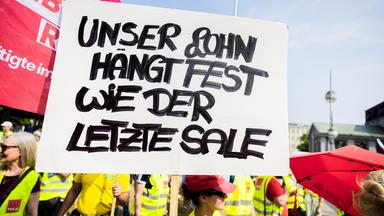 Ein Plakat bei einer Kundgebung zum Warnstreik der Beschäftigen des Einzel- und Großhandels.