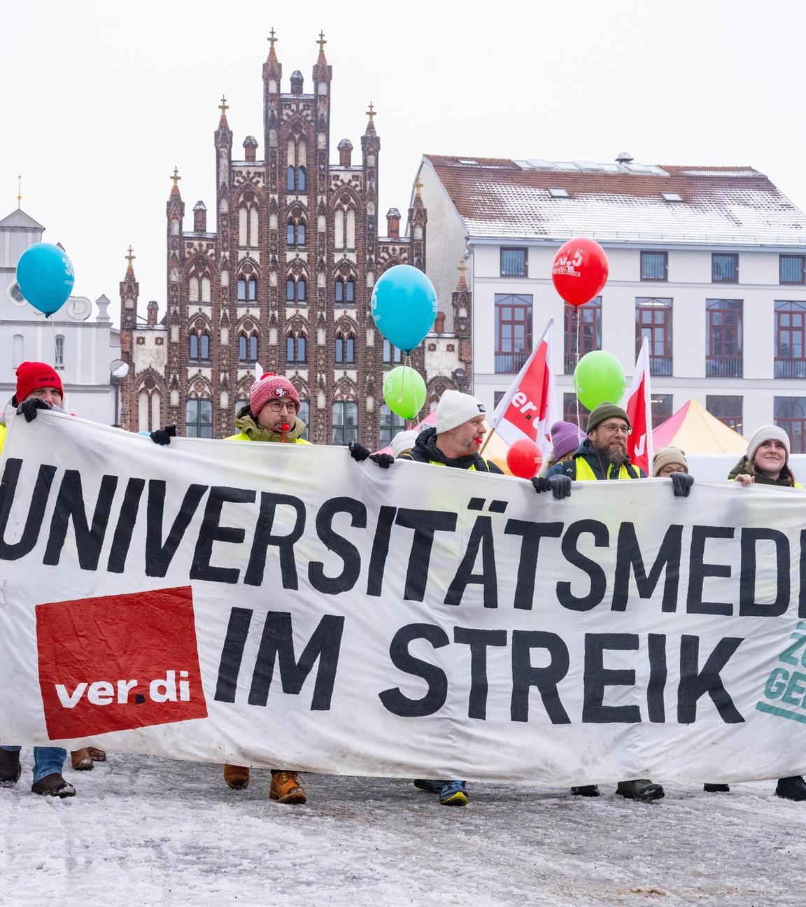 Mecklenburg-Vorpommern, Greifswald: Teilnehmer der Demonstration halten Ballons und tragen ein Banner.
