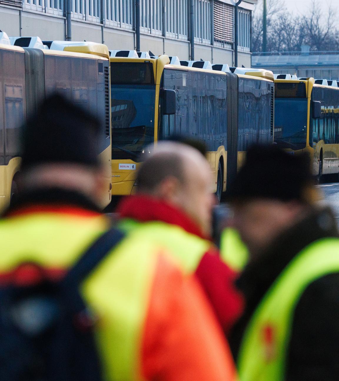 Mitarbeiter mit Warnwesten stehen während eines Warnstreiks im öffentlichen Nahverkehr in Deutschland vor dem BVG-Busdepot Lichtenberg in Berlin am 27. Februar 2026.