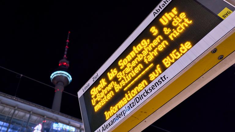 Eine Anzeigetafel an einer Tramhaltestelle am Alexanderplatz informiert über den Streik, im Hintergrund steht der Berliner Fernsehturm.