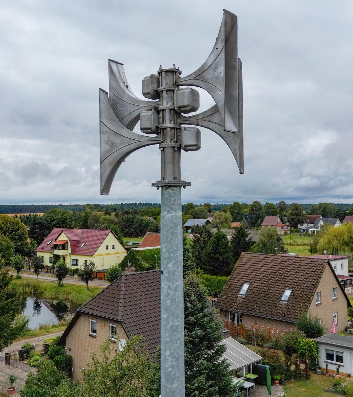 Symbolbild: Eine moderne Sirene ist über einem Dorf zu sehen. 