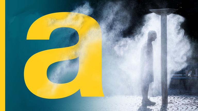 Ein Mann steht unter einer öffentlichen Sprühregendusche.