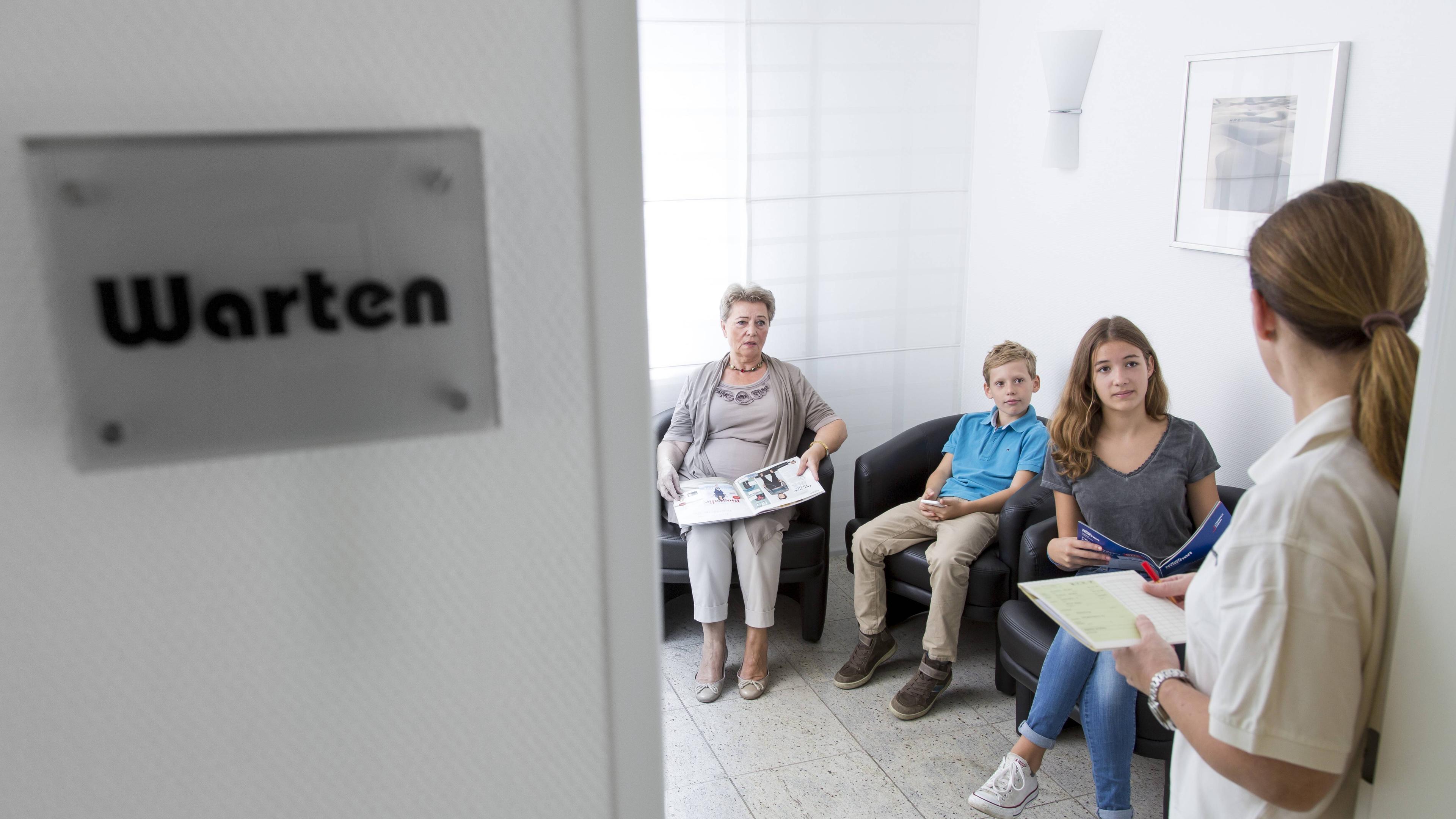 Sprechstundenhilfe ruft einen Patienten auf