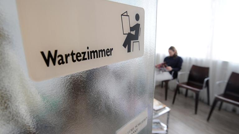 Patientin sitzt in einem Wartezimmer