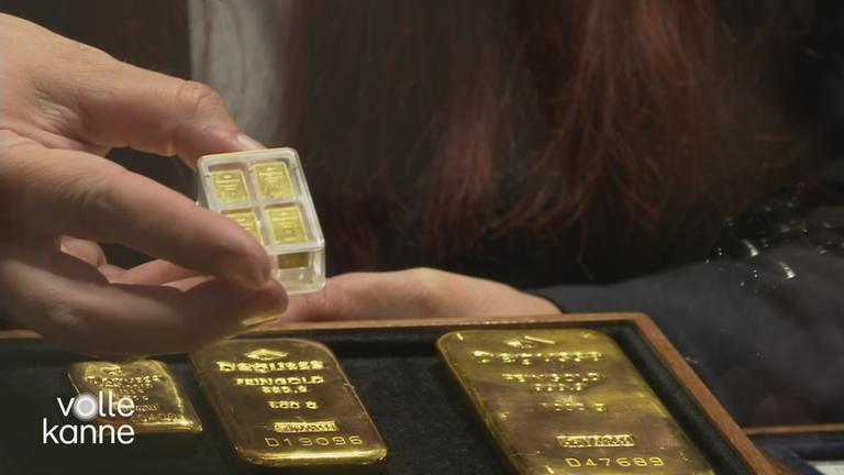 Verschieden grpße Goldbarren liegen vor einer Kundin.