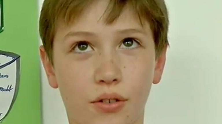 Junge im Karohemd schaut nachdenklich nach oben.