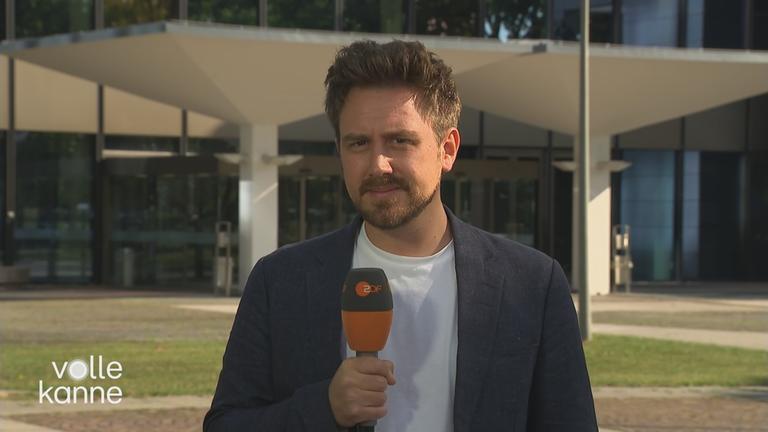 Jan Henrich blickt mit ZDF-Mikro in die Kamera