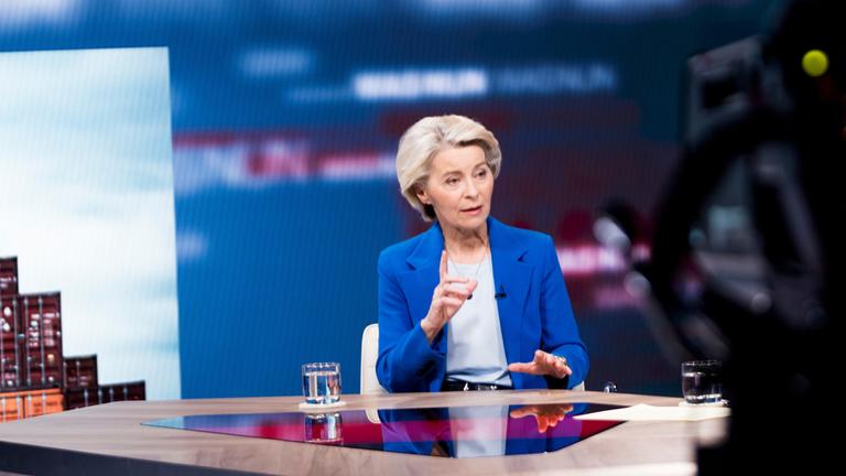 "Was nun, Frau von der Leyen?": Ursula von der Leyen sitzt an einem Tisch.