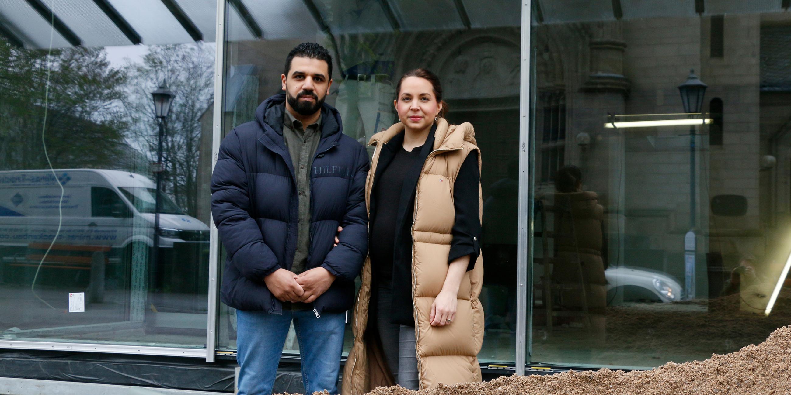 Nora und Soufyan Nechad stehen vor ihrem zukünftigen Optikergeschäft und schauen in die Kamera.
