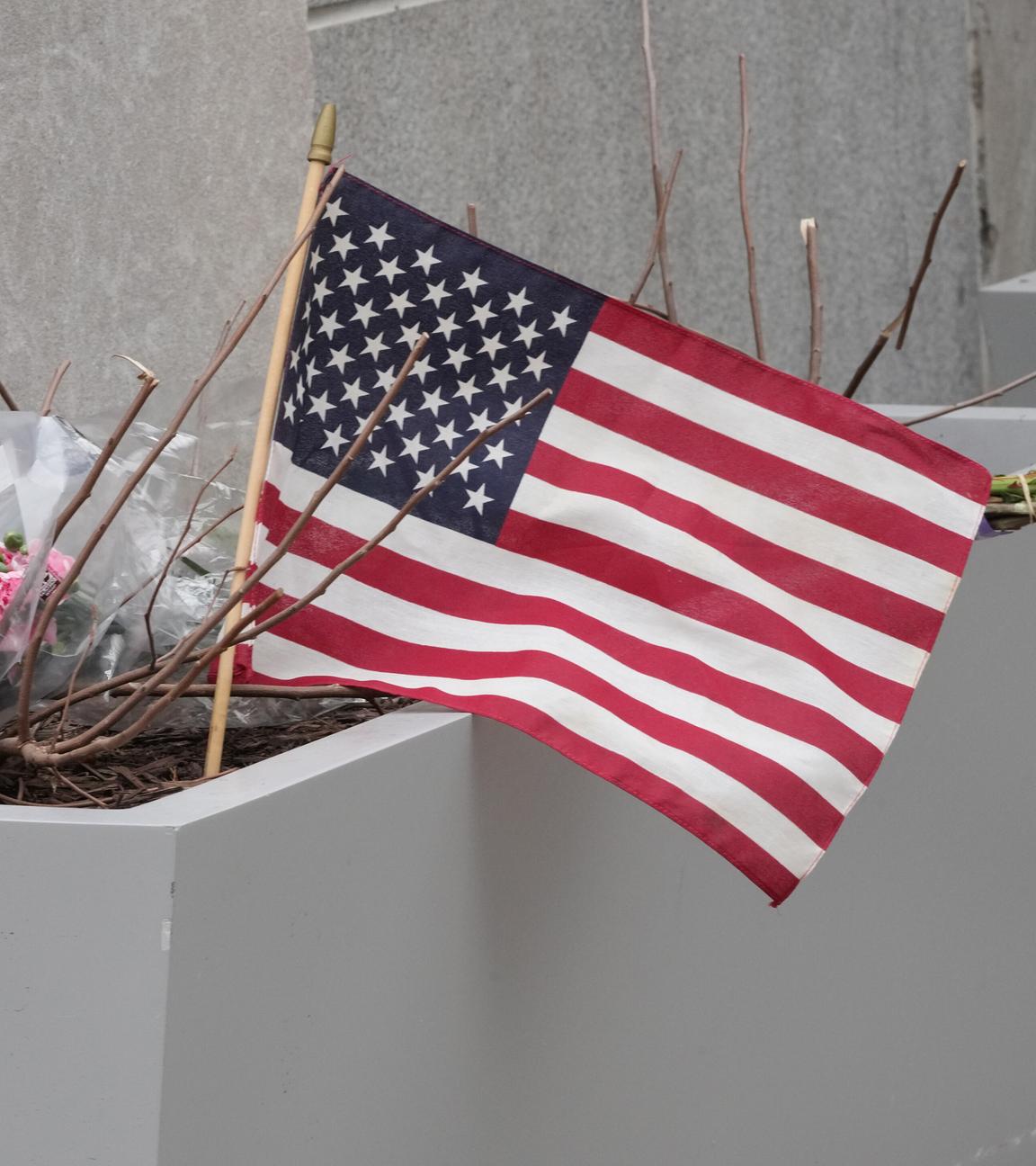 Blumen und eine US-Flagge sind am Tatort der Schüsse auf zwei Nationalgardisten in Washington zu sehen.
