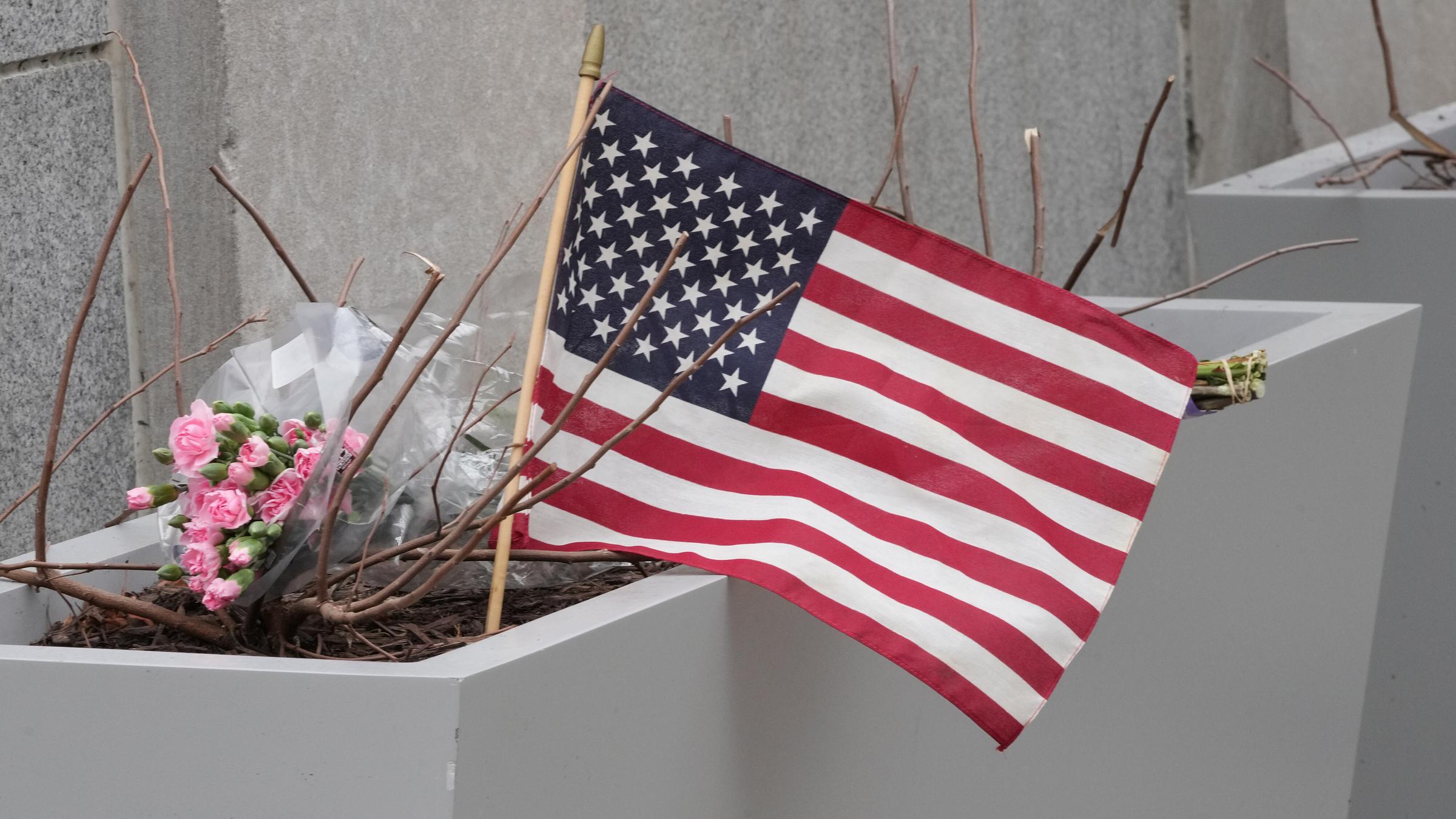 Blumen und eine US-Flagge sind am Tatort der Schüsse auf zwei Nationalgardisten in Washington zu sehen.