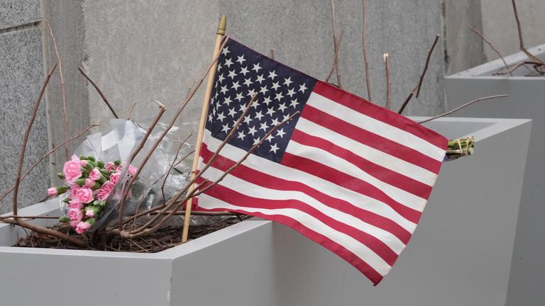 Blumen und eine US-Flagge sind am Tatort der Schüsse auf zwei Nationalgardisten in Washington zu sehen.