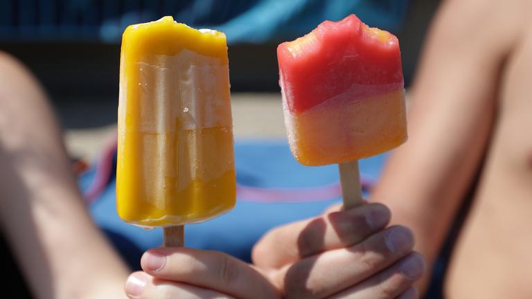 Zwei Personen halten jeweils ein Eis am Stiel.