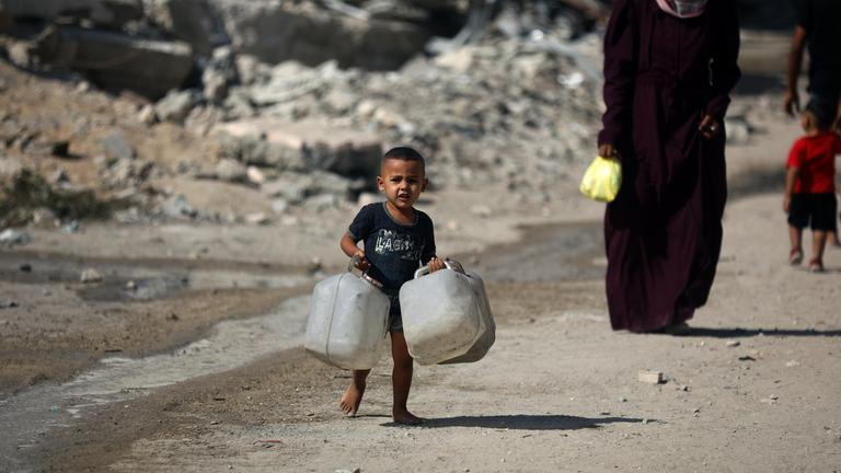 Ein kleiner Junge trägt Wasserkanister 