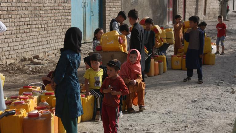 Kinder mit Plastikkanister warten an Brunnen in Kabul.