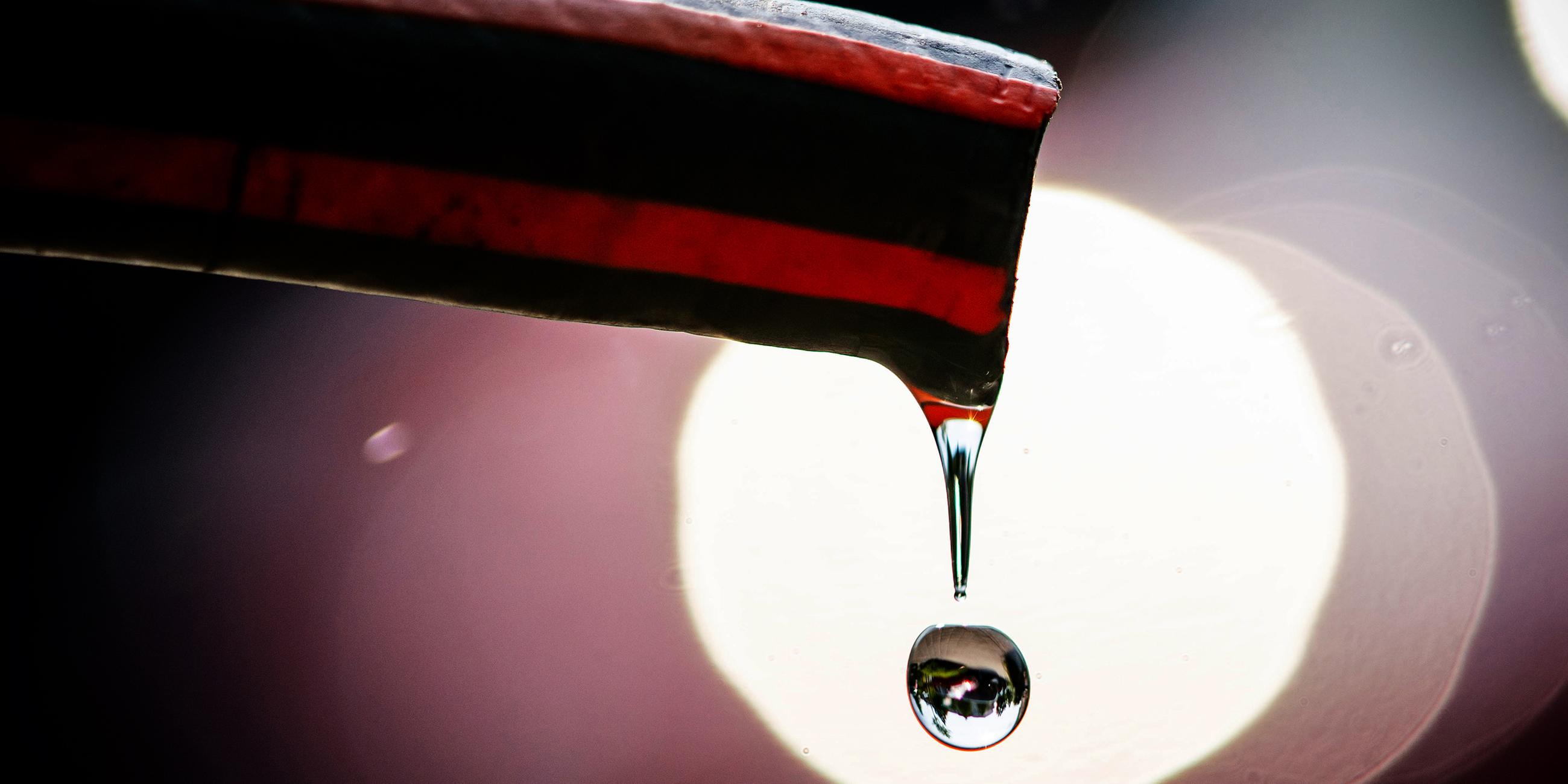 Wasser tropft aus einem Gartenschlauch