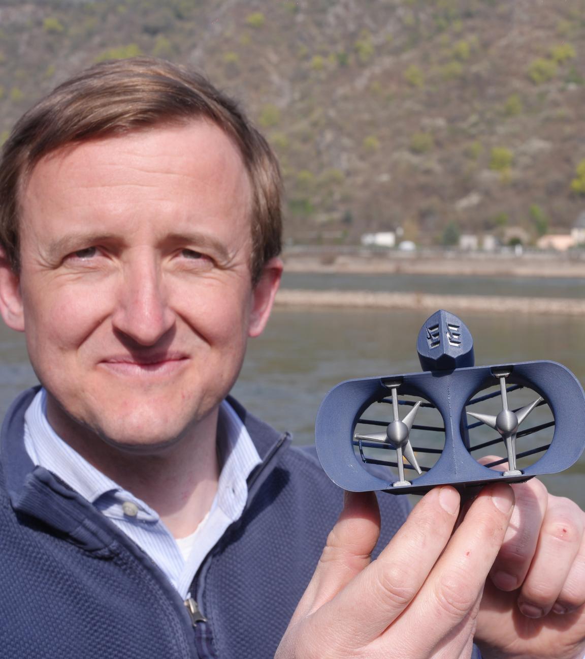 Georg Walder, Co-CEO der Energyminer GmbH, zeigt ein Modell der Turbine eines Schwarmkraftwerks, das im Rhein bei St. Goar arbeitet.