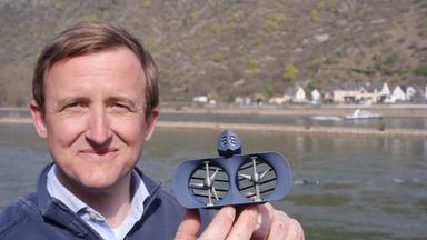 Georg Walder, Co-CEO der Energyminer GmbH, zeigt ein Modell der Turbine eines Schwarmkraftwerks, das im Rhein bei St. Goar arbeitet.