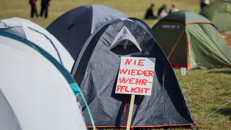  "Nie wieder Wehrpflicht" steht auf einem Schild vor einem Zelt im Protestcamp des Bündnisses Rheinmetall Entwaffnen