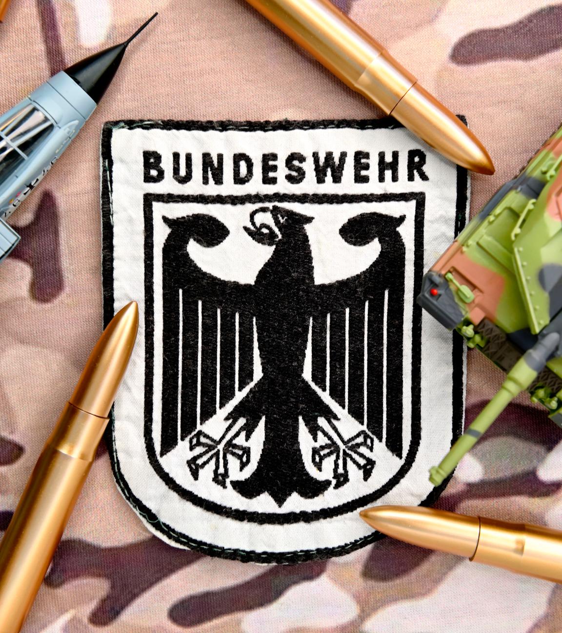 Bundeswehrabzeichen auf Camouflage-Muster, Symbolfoto Wehrdienst und Wehrpflicht