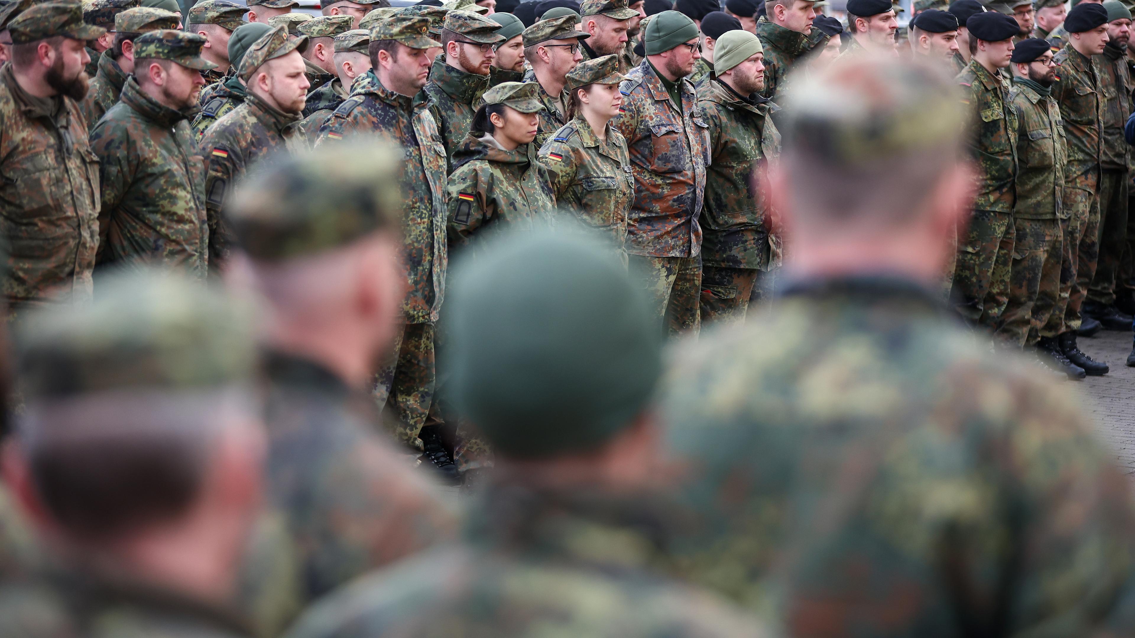 Bundeswehr Soldaten und Soldatinnen stehen vor ihrem Einsatz zusammen.